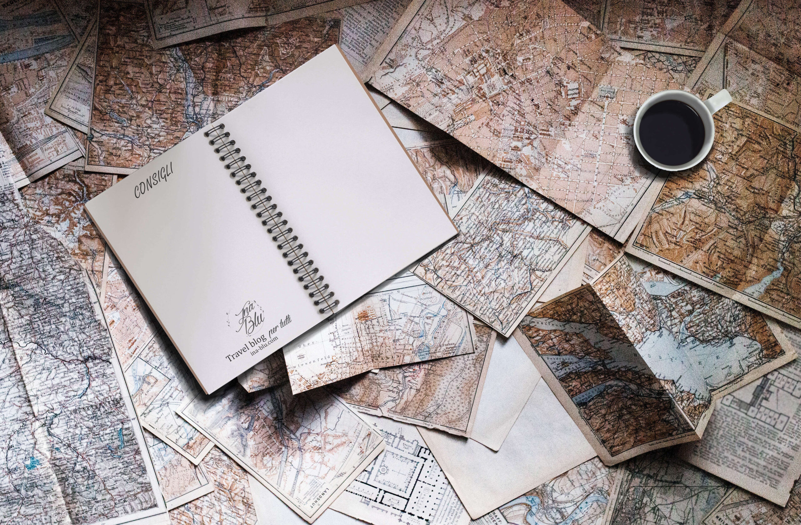 consigli accessibili di ina-blu.com, nell'immagine un quaderno aperto ed una tazza di caffè su cartine del mondo