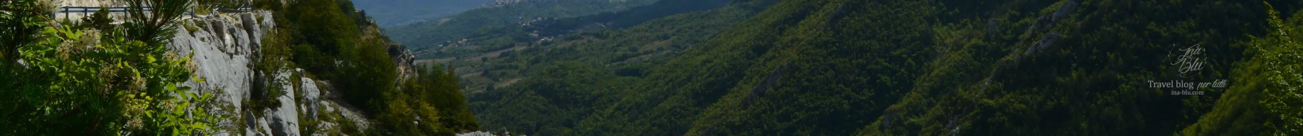 Ritaglio immagine travel blog ina-blu,com. Nell'immagine si vedono montagne verdi sia lateralmente che sullo sfondo.